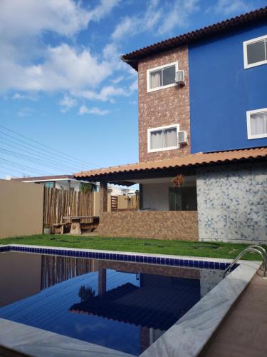 a house and a swimming pool in front of a house at Pousada Mangata in Maragogi