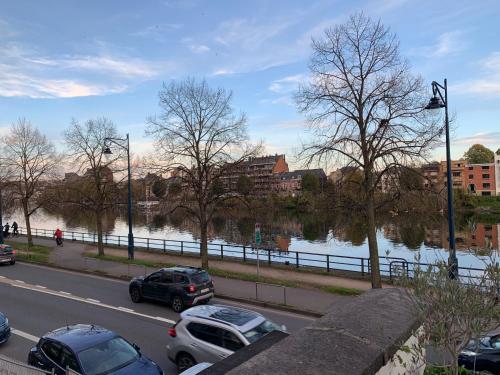 una calle con coches estacionados junto a un río en Studio vue sur Meuse, en Namur
