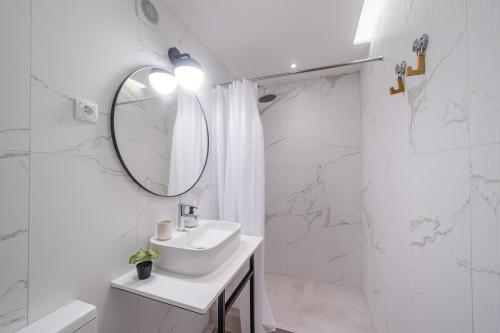 a white bathroom with a sink and a mirror at Apartman Nika in Pirot