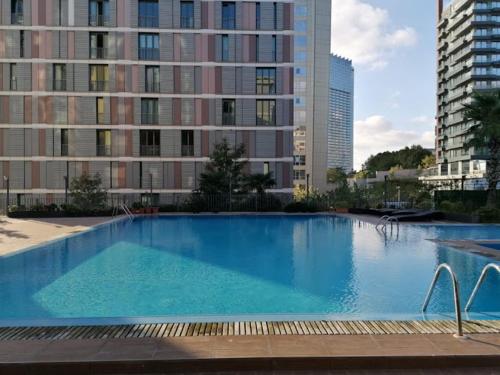 a large swimming pool in a city with tall buildings at studio cozy Home in Istanbul