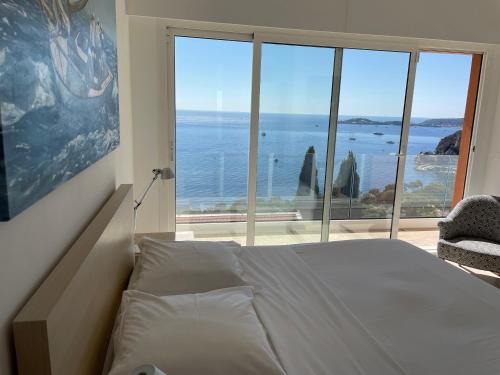 a bedroom with a bed and a view of the ocean at Villa Eze Vue Mer in Èze
