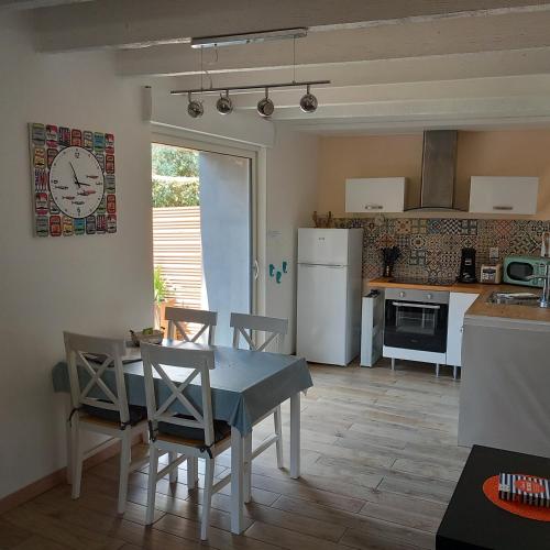 a kitchen and dining room with a table and chairs at La Demoiselle du Finistère in Plobannalec-Lesconil