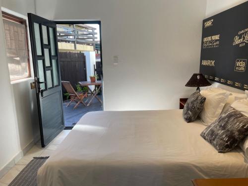 a bedroom with a bed and a door to a patio at Aloe Studio in Jeffreys Bay