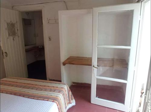 a room with a bed and a sliding glass door at Punta del Este. Habitación privada con baño y entrada independiente. Wifi y cocina comunitaria in Punta del Este