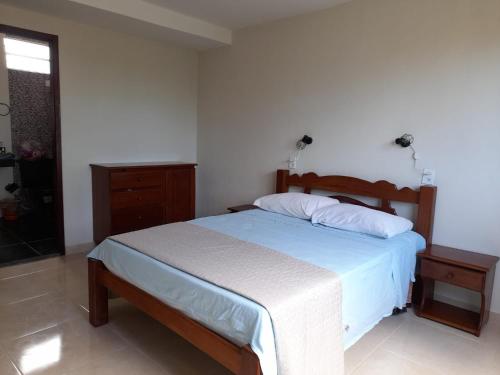 a bedroom with a large bed with a wooden headboard at Casa Mar Azul in São José da Coroa Grande