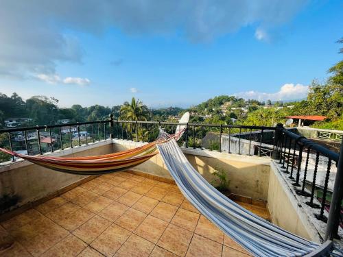 a hammock on the balcony of a house at 中国蒲公英民宿Dandelion Guest house Villa with Mount View in Kandy