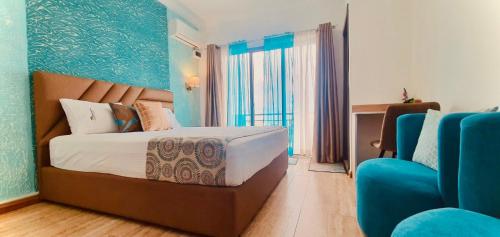 a bedroom with a bed and a blue wall at Mont Oreb Villas Onyx Flic en Flac in Flic-en-Flac