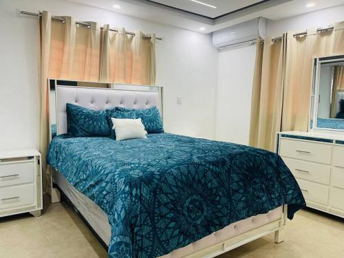 サンティアゴ・デ・ロス・カバリェロスにあるComodo y con Excelente Ubicacionのベッドルーム1室(青い掛け布団付きのベッド1台付)