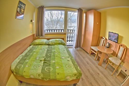 シュクラルスカ・ポレンバにあるWilla Izeryのベッドルーム1室(ベッド1台、テーブル、窓付)