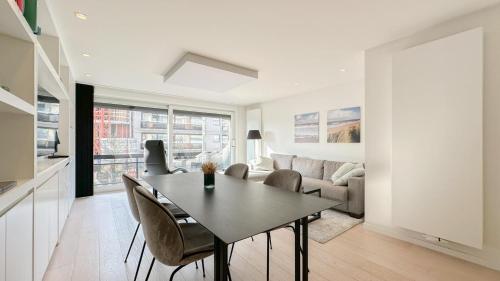 een keuken en een woonkamer met een tafel en stoelen bij Vanbunnen in Knokke-Heist