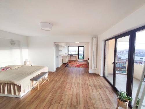 a bedroom with a bed and a large window at Penthouse View 29 in Piteşti