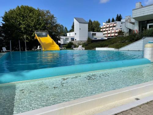 - un toboggan jaune dans la piscine dans l'établissement Hecht Ferienvermietung - Studio Buchfink mit Sauna und Schwimmbad, à Sankt Englmar