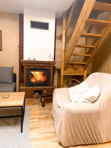a living room with a couch and a fireplace at Chata przy lesie in Łuka