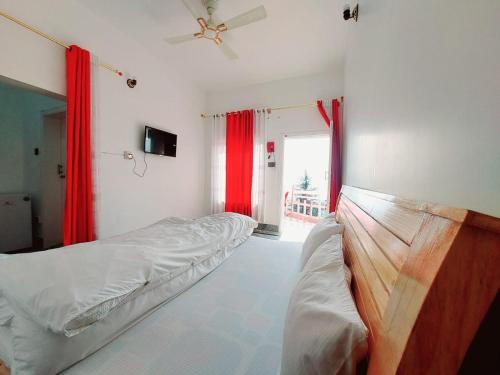 a bedroom with two beds and red curtains at RED ROSE HOTEL & RESORT Mansehra in Mānsehra