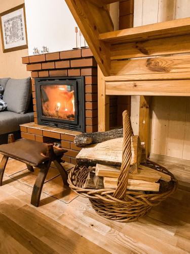 a living room with a fireplace and a chair at Chata przy lesie in Łuka