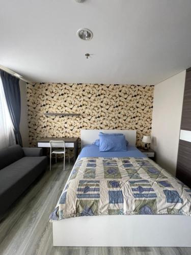 a bedroom with a king sized bed and a couch at ICON ROOMS in Pondokaren