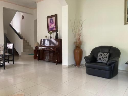 a living room with a chair and a piano at Mirihana Residence in Nugegoda