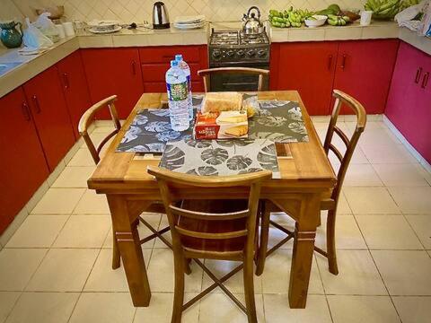 a wooden table with chairs and a bottle of water on it at Mirihana Residence in Nugegoda