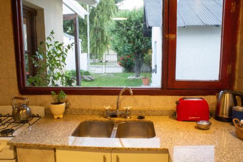 Una encimera de cocina con un fregadero y una ventana. en La Carmela, en Esquel