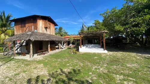 een huis met een rieten dak en een tuin bij Morada Venturi in Atins