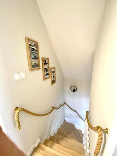 a staircase in a house with white walls and wooden floors at Całoroczny Domek Hampton Lubniewice, jezioro, jacuzzi in Lubniewice