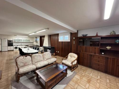 ein Wohnzimmer mit einem Sofa, Stühlen und einem Tisch in der Unterkunft Casa Kiros in Cangas