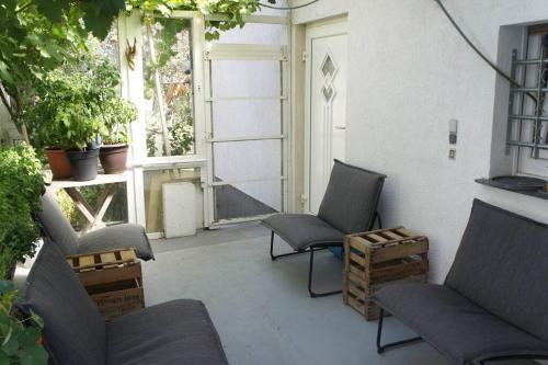une terrasse avec 2 chaises et une porte ornée de plantes dans l'établissement Ruhiges Apartment & Veranda mit guter Anbindung, à Bochum