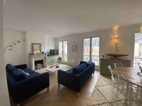 un salon avec des canapés bleus et une table dans l'établissement Trocadero, Tour Eiffel, Duplex 120 m2, à Paris