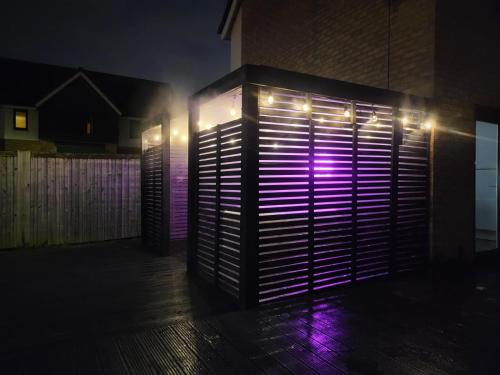 a lit up door with lights on the side of a building at LUXE INN, Birmingham Airport & NEC, FREE Parking in Marston Green