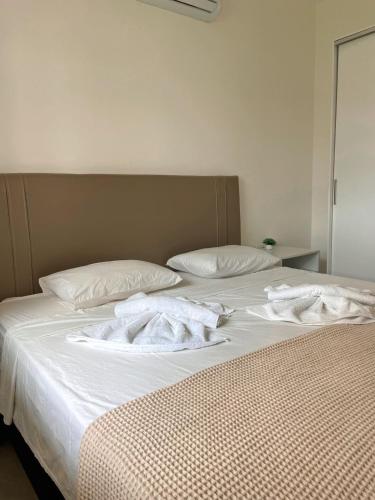 two beds with white towels on top of them at Quality - Boas Vistas in Canoa Quebrada