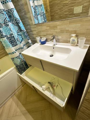 a bathroom with a white sink and a mirror at Casa del sasso in Bergeggi