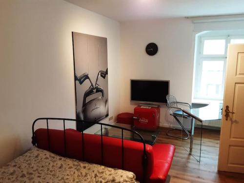 a living room with a red couch and a tv at Alfred First in Regensburg