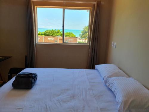 Pousada Mangata في ماراغوغي: سرير في غرفة مع نافذة كبيرة