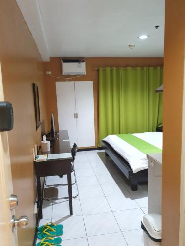 a bedroom with a bed and a desk with a computer at Sab R. Bel air soho in Manila