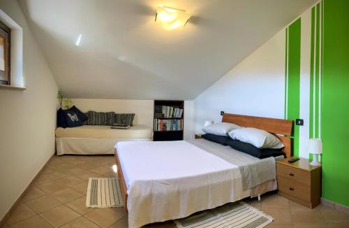 a bedroom with a large white bed and a couch at Iacobhouse, casa con giardino esclusivo e parcheggio privato con vista sul Gran Sasso in Castelbasso