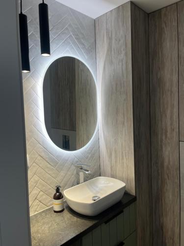 y baño con lavabo y espejo. en Modern Apartament Gdynia, en Gdynia