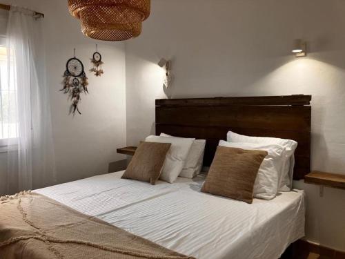 ein Bett mit weißer Bettwäsche und Kissen in einem Schlafzimmer in der Unterkunft Casita Palmera in Casas Abiar