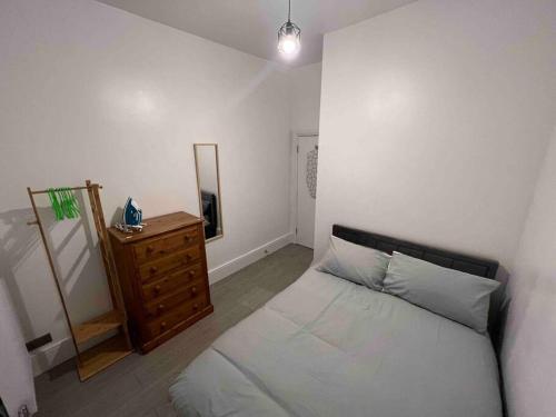 Schlafzimmer mit einem Bett, einer Kommode und einem Spiegel in der Unterkunft 2 Bed Apartment in Central London on 3rd floor - Newly refurbished - No lift in London