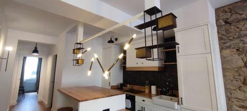 a kitchen with white cabinets and a wooden counter top at Calle Real con patio in Ferrol