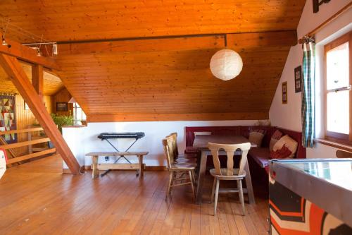- un salon avec des plafonds en bois, une table et des chaises dans l'établissement Gîte du Pré au Miel en plein coeur de l'Alsace, à Sainte-Croix-aux-Mines