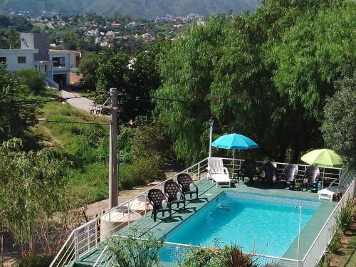 una piscina con sillas y sombrillas junto a en Complejo Casitas De Emma en Villa Carlos Paz