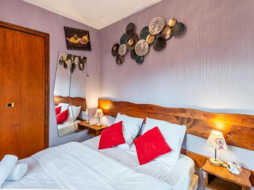 - une chambre avec un lit doté d'oreillers rouges et d'un miroir dans l'établissement Appartement Centre Morzine à 200m des Pistes, 4 Pers, Balcon, Parking, Wifi, Linge Inclus - FR-1-754-65, à Morzine