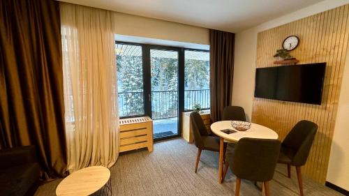 a hotel room with a table and a large window at Apartment Kokhta-Mitarbi B3 408 in Bakuriani