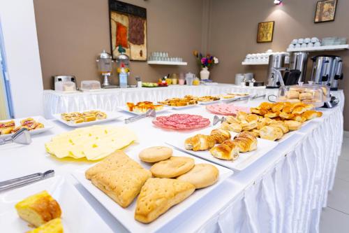 una mesa larga llena de diferentes tipos de repostería en Hotel Cuesta de Miranda en Villa Unión