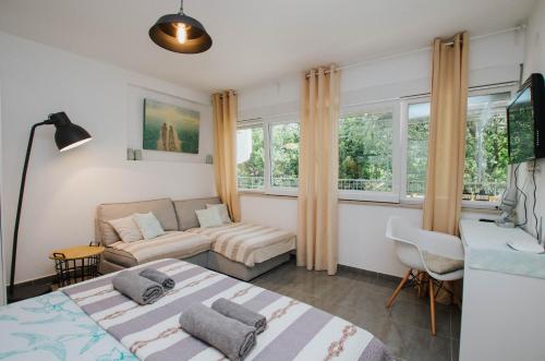 1 dormitorio con 2 camas, sofá y ventanas en Mamma mia apartments-city center, en Hvar