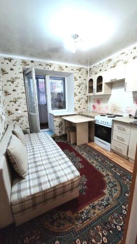 salon z łóżkiem i kuchnią w obiekcie Аэропорт Астана 5 минут юг1 582 w mieście Prigorodnyy
