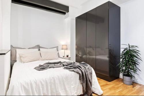 a bedroom with a large bed and a black cabinet at Super cozy apartment in the heart of Bergen city in Bergen