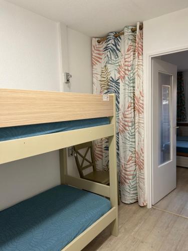 łóżko piętrowe w pokoju z drzwiami w obiekcie Domaine Valescure vue Piscine ou Pinede - Wifi w miejscowości Saint-Raphaël