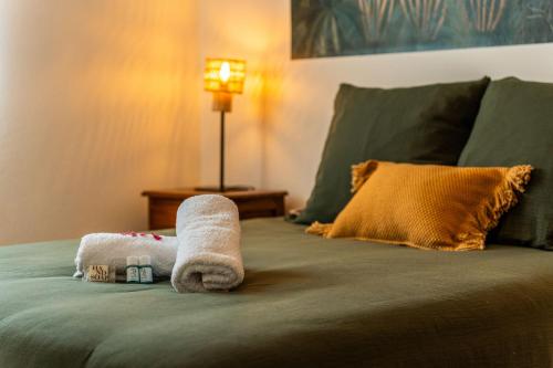a bed with two towels and a pillow on it at Villa Marinia 3*: Charme Créole in Saint-Denis