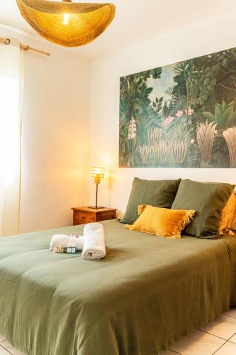 a bedroom with a large bed with two towels on it at Villa Marinia 3*: Charme Créole in Saint-Denis
